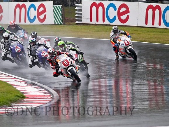 Adam Jenkinson leads into the 1st corner as John McGuinness runs wide